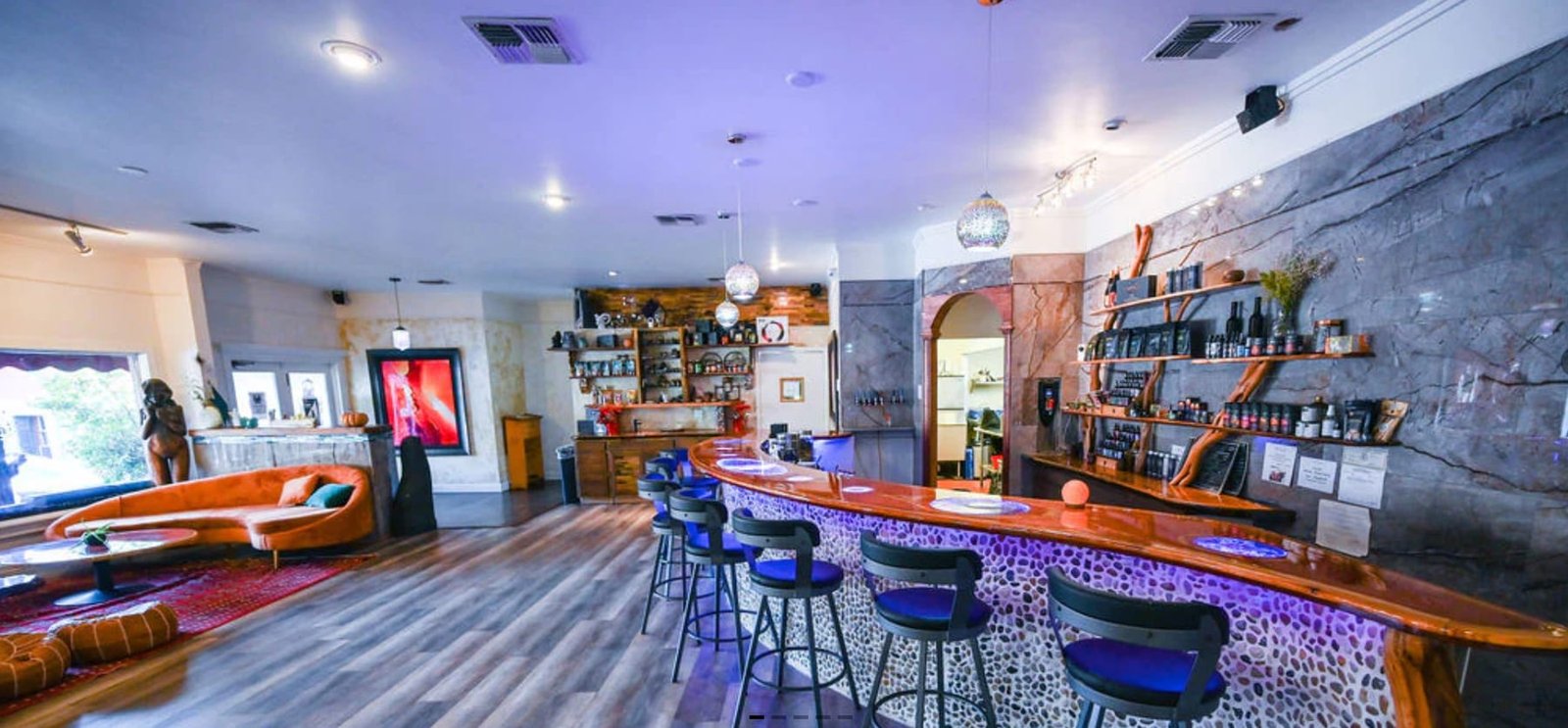 Elixir bar with a curved counter and blue stools