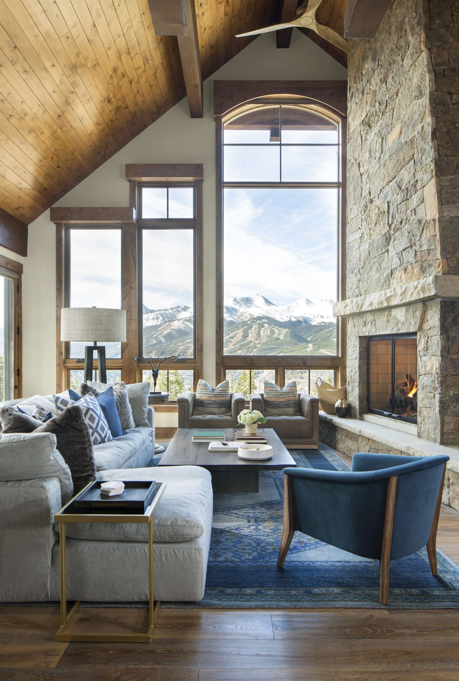 Luxury mountain home with glass walls and a stone chimney